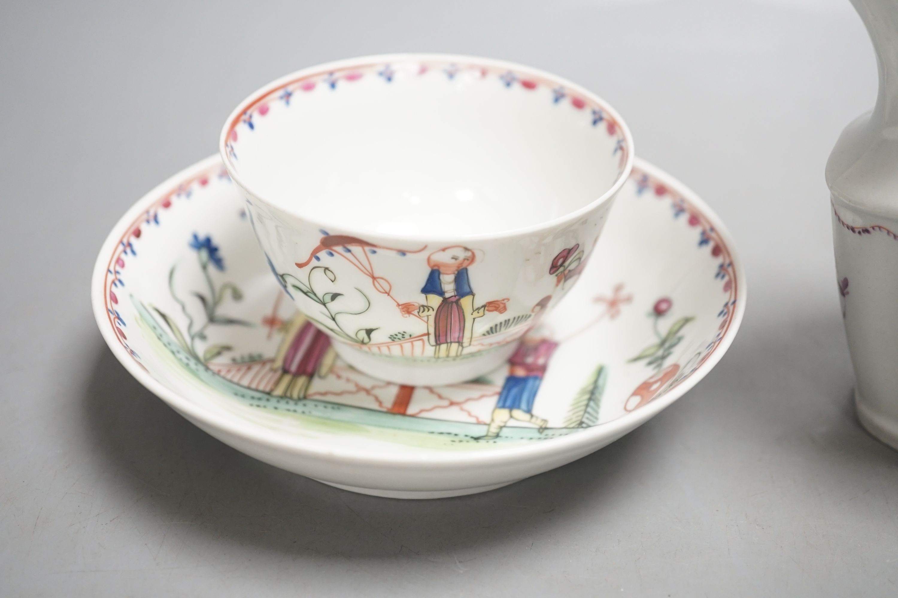 A New Hall teabowl and saucer painted with oriental children with either a pinwheel or a parasol pattern no. 20 and a cream jug painted with flowers pattern 253 C.1785